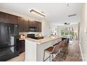 Open concept kitchen with granite countertops, dark cabinetry, stainless appliances, and breakfast bar seating at 837 Seigle Point Dr, Charlotte, NC 28204