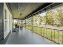 Covered front porch with black metal railing and sitting area at 1013 East Dr, Gastonia, NC 28052