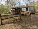 A charming, rustic-style home is showcased with a simple fence and natural landscaping in a tranquil setting at 104 Little River Trl, Fort Mill, SC 29707