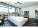 Living room with floor-to-ceiling windows, white sofa, and a view to the outdoor patio at 1100 Metropolitan Ave # 314, Charlotte, NC 28204