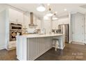 Modern kitchen features stainless steel appliances, white cabinetry, large island with bar seating, and stylish pendant lighting at 11019 Kilkenny Dr # 41, Charlotte, NC 28277