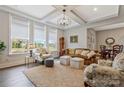 Bright living room boasts tray ceilings, large windows, neutral color palette, and comfortable furnishings at 11019 Kilkenny Dr # 41, Charlotte, NC 28277