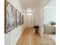 Bright hallway with wood floors, white walls, and decorative art leading to an office space at 11036 Shreveport Dr, Huntersville, NC 28078