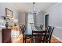 Elegant dining room with hardwood floors, a modern chandelier, and large windows offering ample natural light at 1537 Wheaton Nw Way, Concord, NC 28027