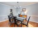 Formal dining room featuring hardwood floors, modern chandelier, and ample natural light at 1537 Wheaton Nw Way, Concord, NC 28027