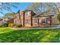 Charming two-story brick home with a lush green lawn and mature trees, creating a welcoming curb appeal at 1537 Wheaton Nw Way, Concord, NC 28027