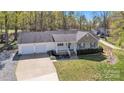 Spacious single-story home featuring brick accents, two car garage and a wide driveway in a wooded area at 1584 Beverly Ln, Lincolnton, NC 28092