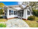 Back view of a charming home featuring a screened porch and stone patio at 165 Mimosa Ter, Wadesboro, NC 28170