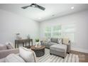 Inviting living room with modern furnishings, natural light, and sleek ceiling fan at 19751 Feriba Pl, Cornelius, NC 28031