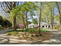 Long driveway leading to a white brick single-story home surrounded by mature trees and lush landscaping at 2015 Pellyn Wood Dr, Charlotte, NC 28226