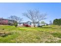 Exterior view of home with lawn, mature trees, deck, and blue sky background at 216 Sylvan Rd, China Grove, NC 28023