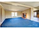 Spacious living room featuring blue carpeting, fireplace, and natural light from window at 216 Sylvan Rd, China Grove, NC 28023