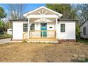 Charming white home featuring a covered front porch with a bright blue front door and a well-manicured lawn at 243 Barber St, Rock Hill, SC 29730