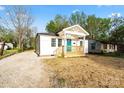 Charming white home featuring a covered front porch with a bright blue front door and a well-manicured lawn at 243 Barber St, Rock Hill, SC 29730