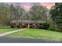 Charming brick home with a well-manicured front yard and mature trees at 2714 Dogwood Cir, Charlotte, NC 28208