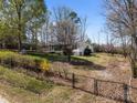 Fenced backyard featuring the house with a screen porch, wheelchair ramp, a carport, and mature trees at 404 Forest Winds Dr, Salisbury, NC 28144