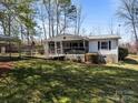 Charming single-story home featuring a screened porch, wheelchair ramp, and carport surrounded by trees at 404 Forest Winds Dr, Salisbury, NC 28144