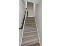 Carpeted staircase with wooden handrail provides a seamless transition between floors at 408 Moondance Dr # C, Gastonia, NC 28054