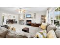 Bright living room featuring a fireplace, ceiling fan, and large windows for natural light at 4380 Timberwood Dr, Gastonia, NC 28052