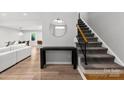 Bright living room with a staircase, featuring modern decor and hardwood floors at 4522 Woods End Ln, Charlotte, NC 28277