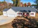 Charming home with a two-car garage, inviting front porch and red accents, set on a well-maintained lot at 4980 Kiser Island Rd, Terrell, NC 28682