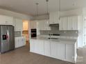 Bright, spacious kitchen with stainless steel appliances, quartz countertops, and a large center island at 5205 Mint Harbor Way # 0353, Charlotte, NC 28269