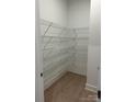 Walk-in pantry with wood floors and ventilated metal shelving providing optimal storage space at 5205 Mint Harbor Way # 0353, Charlotte, NC 28269