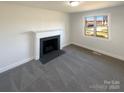 Bright living room featuring a decorative fireplace and a large window for ample natural light at 614 Normandy Rd, Lancaster, SC 29720