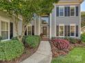 Close-up of a home's front entry featuring a well-lit porch with colorful landscaping and a walkway at 6325 Hawkwood Ln, Charlotte, NC 28277