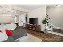 Comfortable living area featuring stylish flooring, a TV, and staircase access at 6354 Old Pineville Rd # F, Charlotte, NC 28217