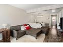 Inviting living room featuring hardwood floors, decorative beams and a plush sectional with ottoman at 6354 Old Pineville Rd # F, Charlotte, NC 28217