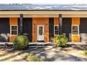 Close up of the front entrance showing black brick, wood trim, fresh landscaping and updated lighting at 7816 Wallace Ln, Charlotte, NC 28212
