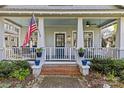 Inviting front porch with an American flag, white railings, and a brick pathway to the front door at 806 Sunnyside Ave, Charlotte, NC 28204