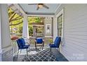 Cozy porch setup with seating, a ceiling fan, and stylish blue accents and a blue patterned rug at 806 Sunnyside Ave, Charlotte, NC 28204