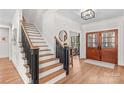 Inviting foyer with hardwood floors, elegant staircase, and a glimpse into a sitting room at 115 Brawley Harbor Pl, Mooresville, NC 28117