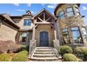 Grand front entrance showcasing stone steps, a wooden portico, and custom iron doors at 1311 Sunnys Halo Ln, Waxhaw, NC 28173