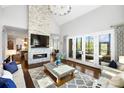 Bright living room with fireplace and stone surround, tall ceilings, and french doors to patio at 1311 Sunnys Halo Ln, Waxhaw, NC 28173