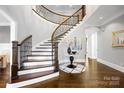 Elegant staircase with hardwood treads, white risers, and wrought iron balusters at 1311 Sunnys Halo Ln, Waxhaw, NC 28173