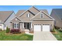 Charming home featuring a two-car garage, beautiful stone accents, and lush green lawn at 14015 Cameryn Elise Dr, Cornelius, NC 28031