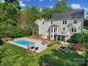 Beautiful backyard oasis featuring a large pool, patio area, and lush landscaping, perfect for outdoor entertaining at 15101 Sharrow Bay Ct # 12, Huntersville, NC 28078