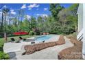 Backyard with a private pool and a lounge area, surrounded by mature trees and landscaping at 15101 Sharrow Bay Ct # 12, Huntersville, NC 28078