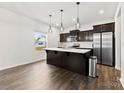Modern kitchen with dark cabinets, stainless steel appliances, and an island with white countertop at 1976 Ethan Ln, Stanfield, NC 28163