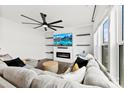 Cozy living room features an electric fireplace, TV, modern ceiling fan and comfortable seating at 1976 Ethan Ln, Stanfield, NC 28163