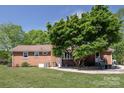 A spacious backyard with a beautiful mature tree providing ample shade and a seating area at 2064 Elizabeth Ave, Hickory, NC 28602