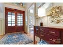 Grand foyer showcasing wood floors, large front doors, elegant accents, and an adjacent vanity area at 2504 White Thorne Ln, Waxhaw, NC 28173
