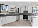 Bright kitchen featuring white cabinets, stainless steel appliances, and dark backsplash at 3437 Byrnes St, Charlotte, NC 28205