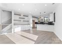 Open-concept living space with wood floors, built-in cabinets, and a view of the kitchen at 3437 Byrnes St, Charlotte, NC 28205