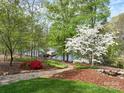 Lake view with brick-paved walkway, manicured lawn, mulched beds, and a quaint boat dock for peaceful lake access at 345 Porters Glen None, New London, NC 28127