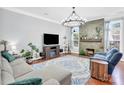 Cozy living room with stone fireplace, hardwood floors, a modern chandelier and lots of natural light at 3701 Arthur St, Indian Trail, NC 28079