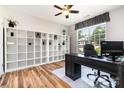 Well-lit office with a large window, modern desk, and extensive built-in shelving for storage at 4001 Brook Valley Run, Monroe, NC 28110